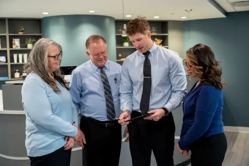 Two chiropractors and two staff members gathered together at the front desk at ProHealth Chiropractic Rockville clinic