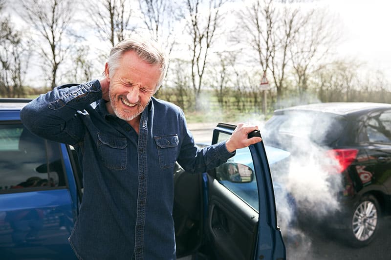 Man holding his neck in pain after a car accident at ProHealth Chiropractic Rockville clinic