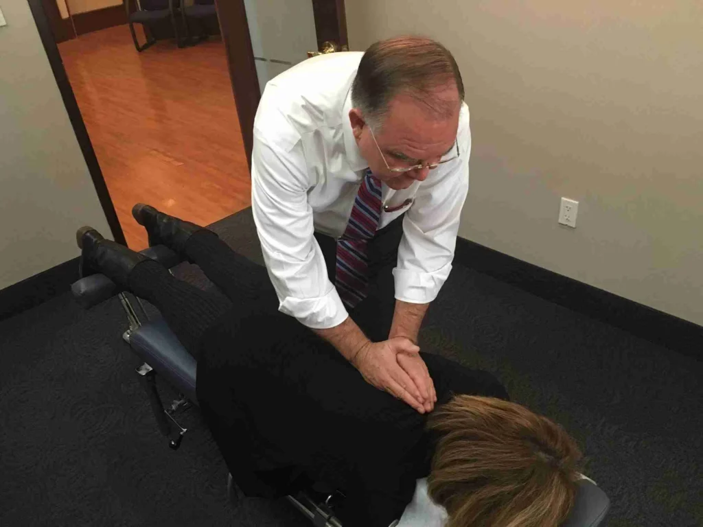 Chiropractor performing a mid-back adjustment on a patient lying face down at ProHealth Chiropractic Rockville clinic