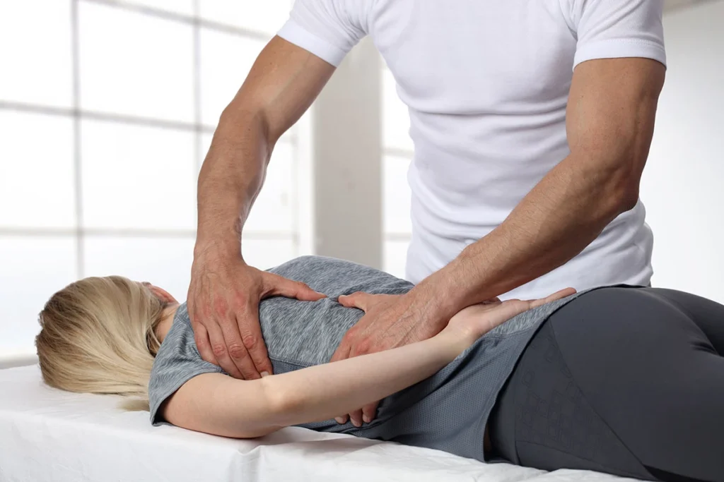 Chiropractor performing a lumbar rotation stretch on a patient lying on their back at ProHealth Chiropractic Rockville clinic
