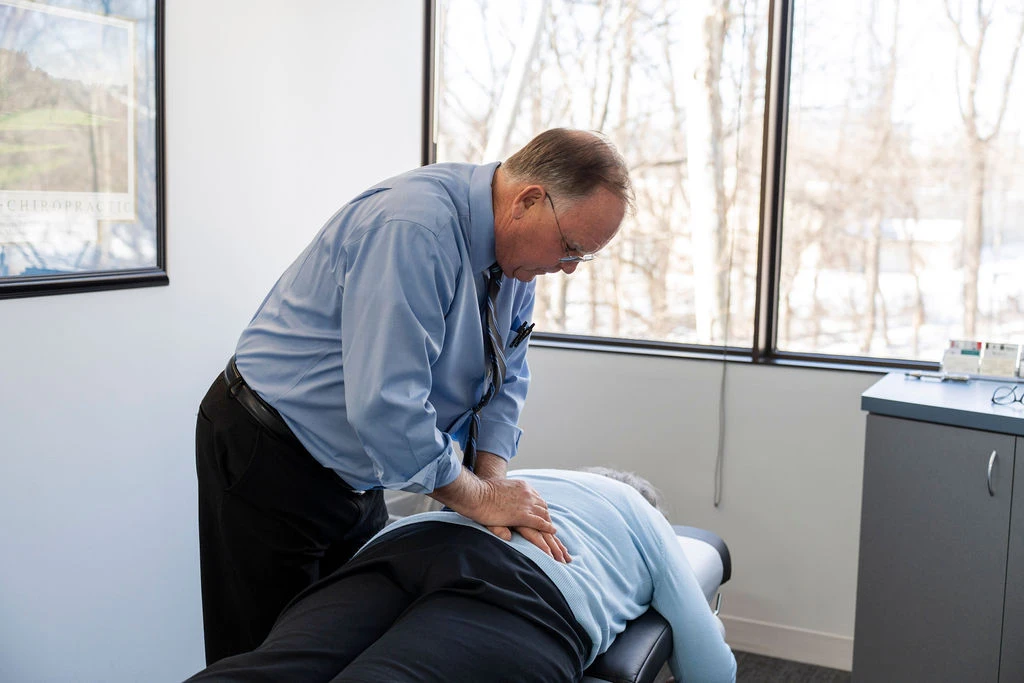 Chiropractor using a spine model during a scoliosis care consultation in Rockville, MD